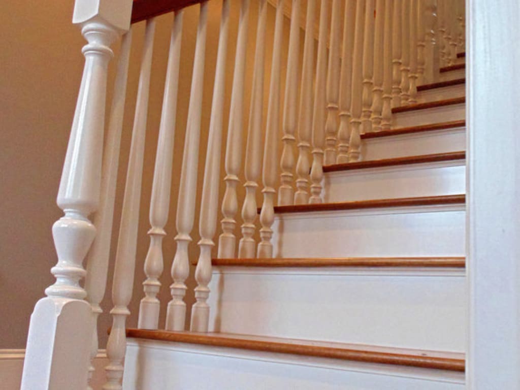 A white staircase with wooden steps and railing.